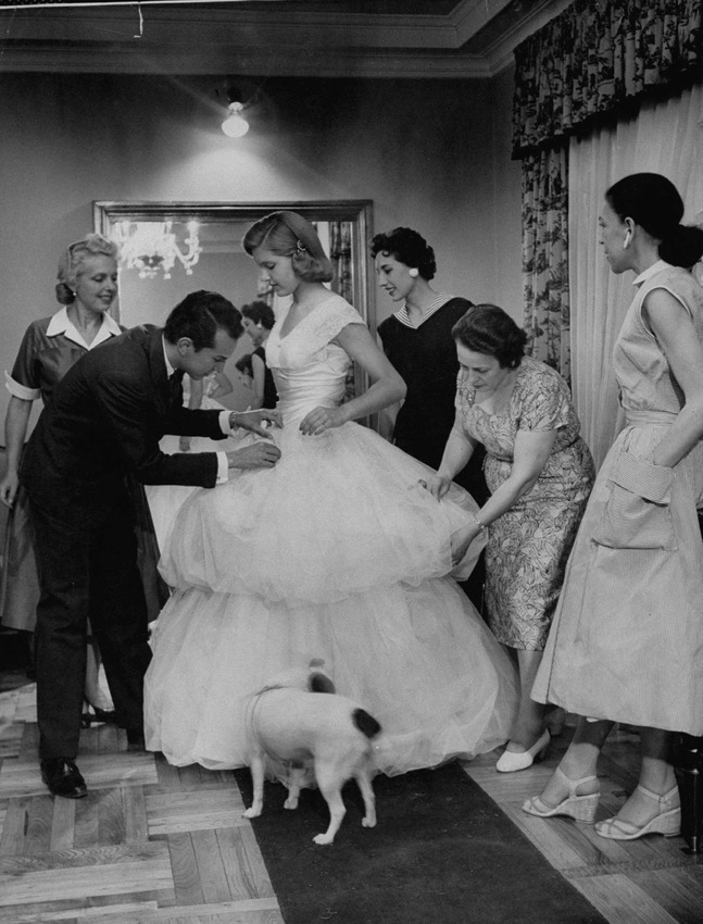 Oscar de la Renta working the last details onto a wedding gown, 1956