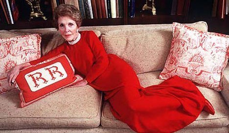 Nancy Reagan lounging in her vibrant red ball gown