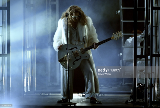 Watt more could you ask for in a rockstar. Musician Watt rocked the stage in his performance with Hailee Steinfeld in a spectacular white full length fox coat at the 2017 American Music Awards