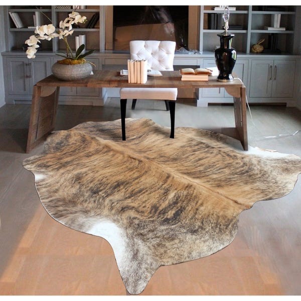 A natural cowhide rug perfectly placed add visual interest on hard surface floors home decor trends